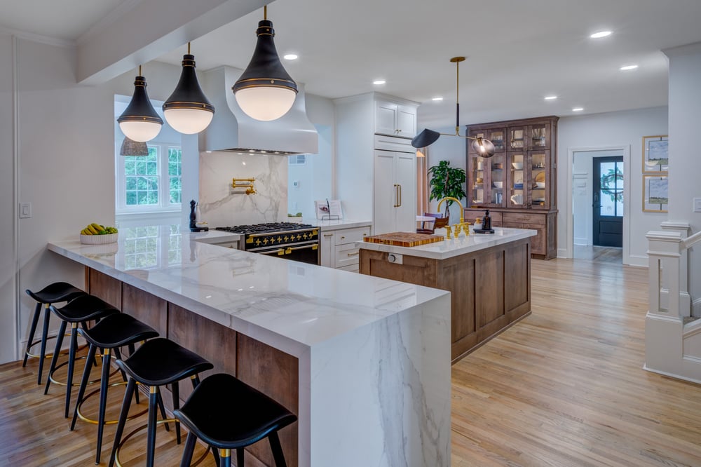 Kitchen remodel in Atlanta with waterfall countertop with seating, statement slab backsplash, wood floors