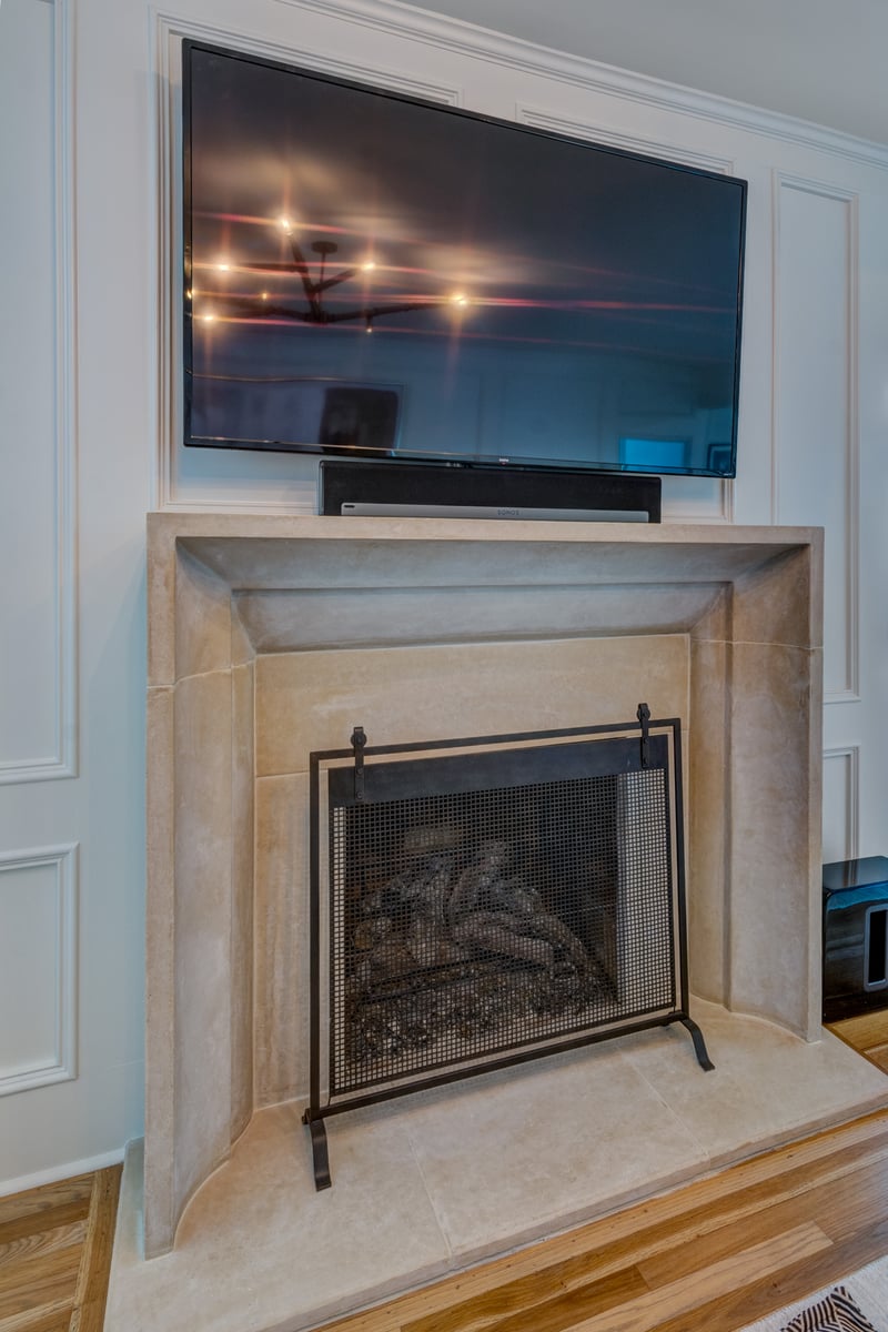 TV over limewash fireplace with paneled trim in Living room remodel in Atlanta