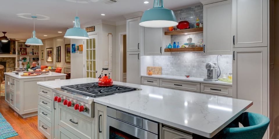 A remodeled kitchen in an Atlanta home with an open layout, white cabinets, and porcelain countertops.