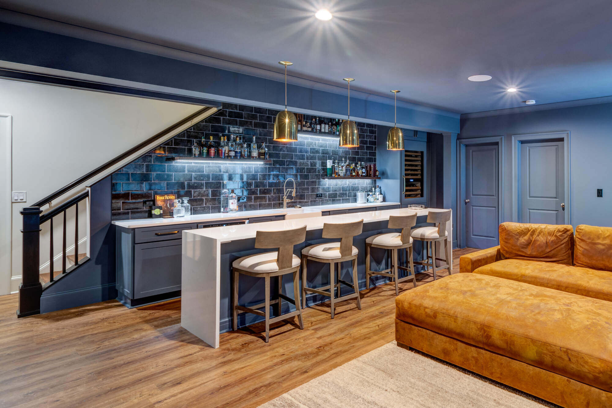 Modern basement bar with navy cabinetry and brass accents by Silver Oak Remodel in Atlanta, GA