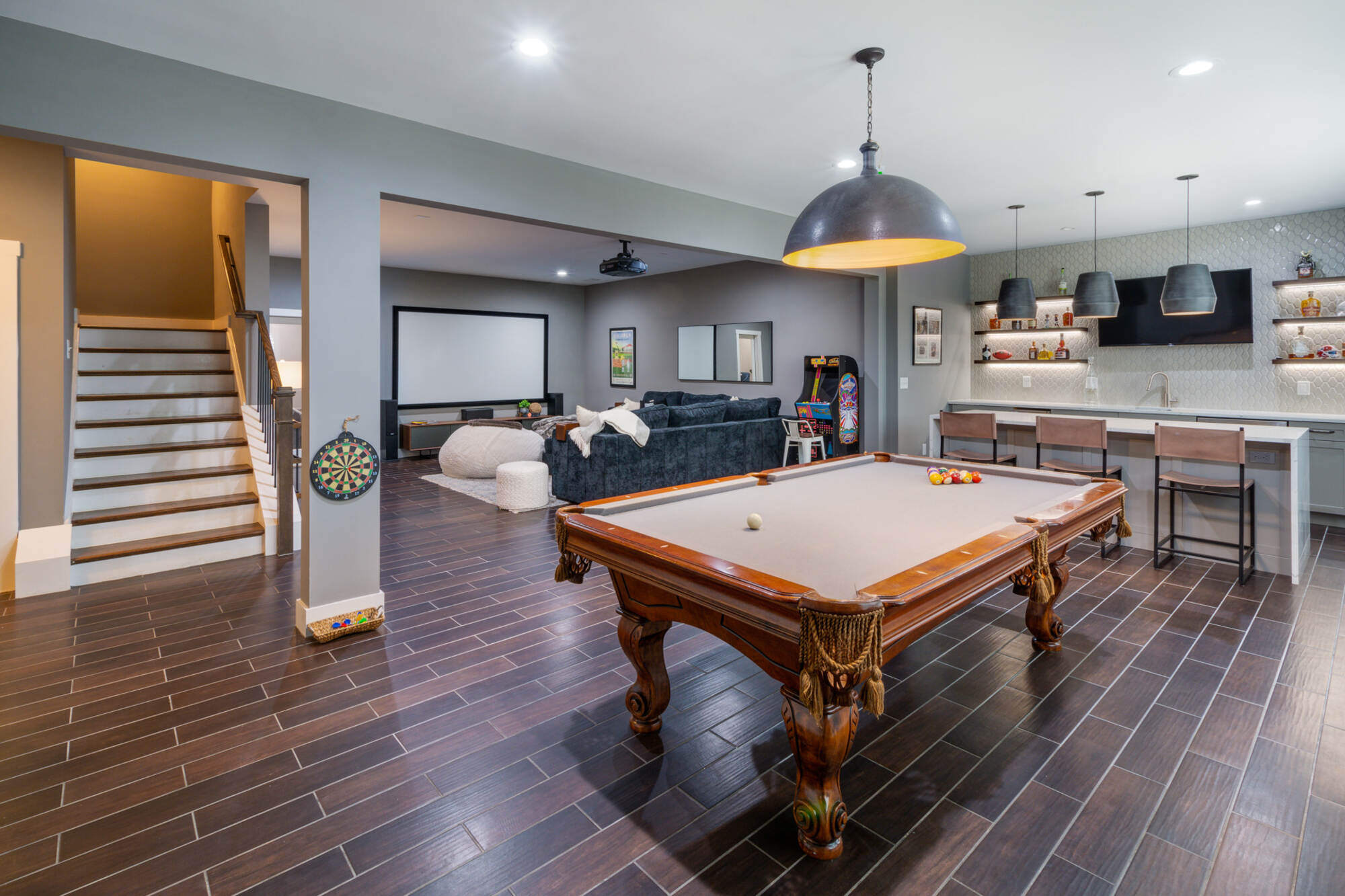 Whole home remodel basement with pool table, home theater, and modern bar by Silver Oak Remodel in Brookfield, GA