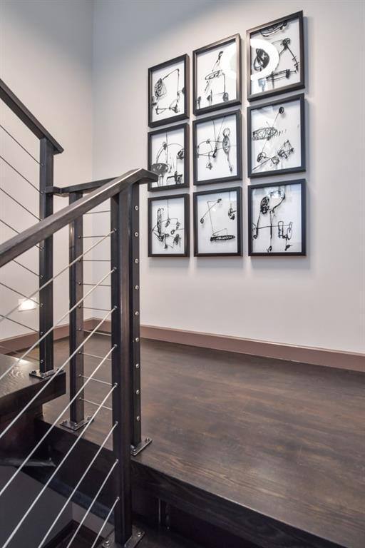 Artistic staircase landing with dark wood floors in Atlanta basement by Silver Oak Remodel