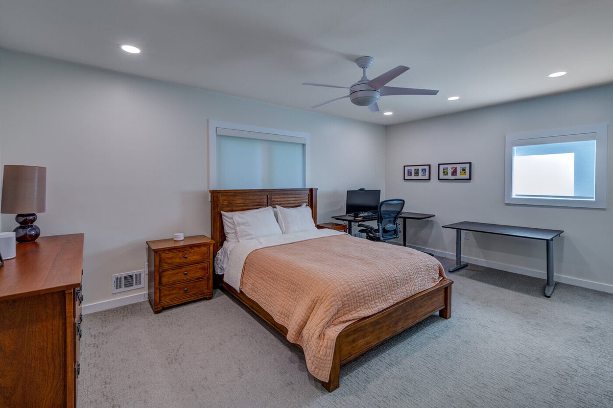 Basement bedroom remodel with wood furniture and home office setup in Atlanta GA by Silver Oak Remodel