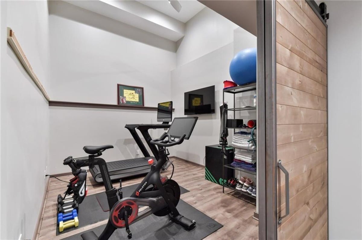 Basement gym with Peloton bike and treadmill by Silver Oak Remodel in Atlanta, GA