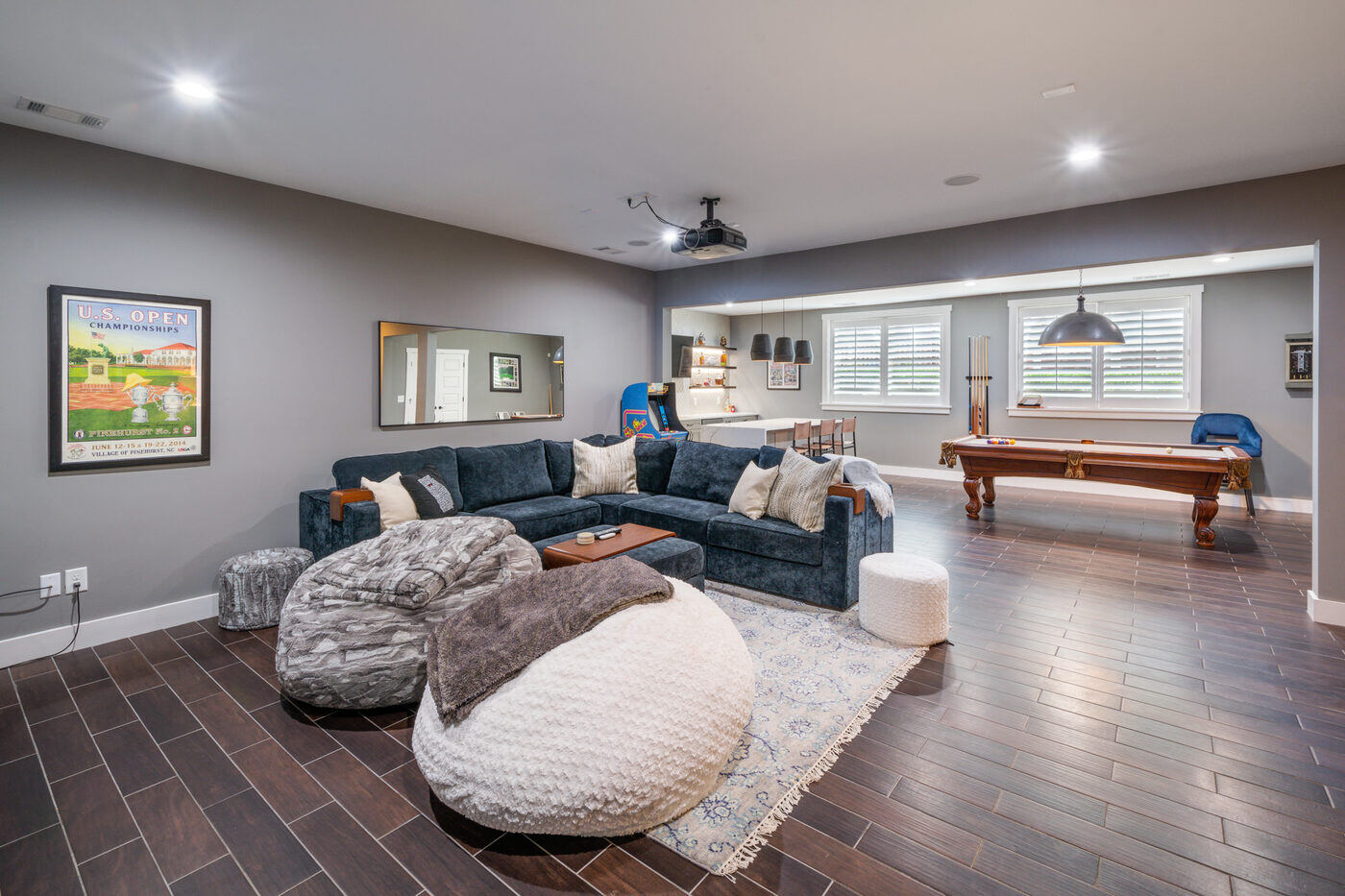 Basement lounge space with sectional and pool table in Atlanta remodel by Silver Oak Remodel