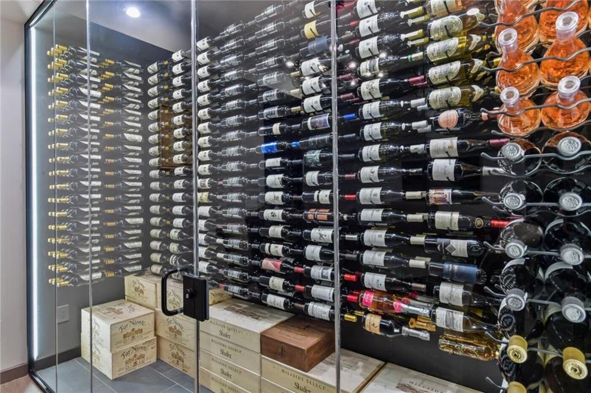 Basement wine cellar with glass enclosure and wall-mounted wine racks by Silver Oak Remodel in Atlanta, GA