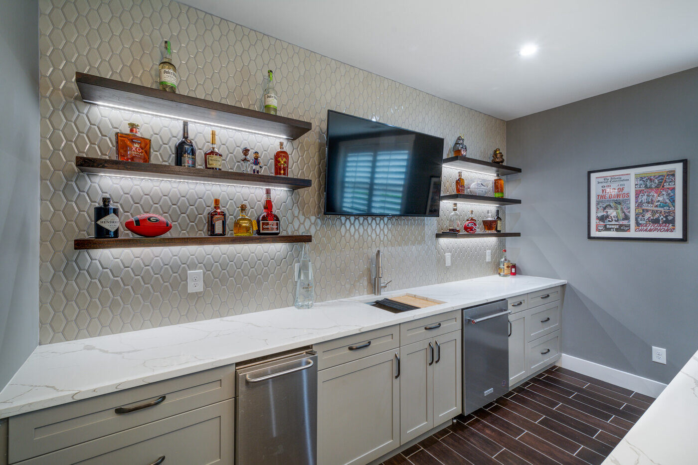 Custom bar area in Atlanta basement remodel by Silver Oak Remodel with floating shelves and tile backsplash