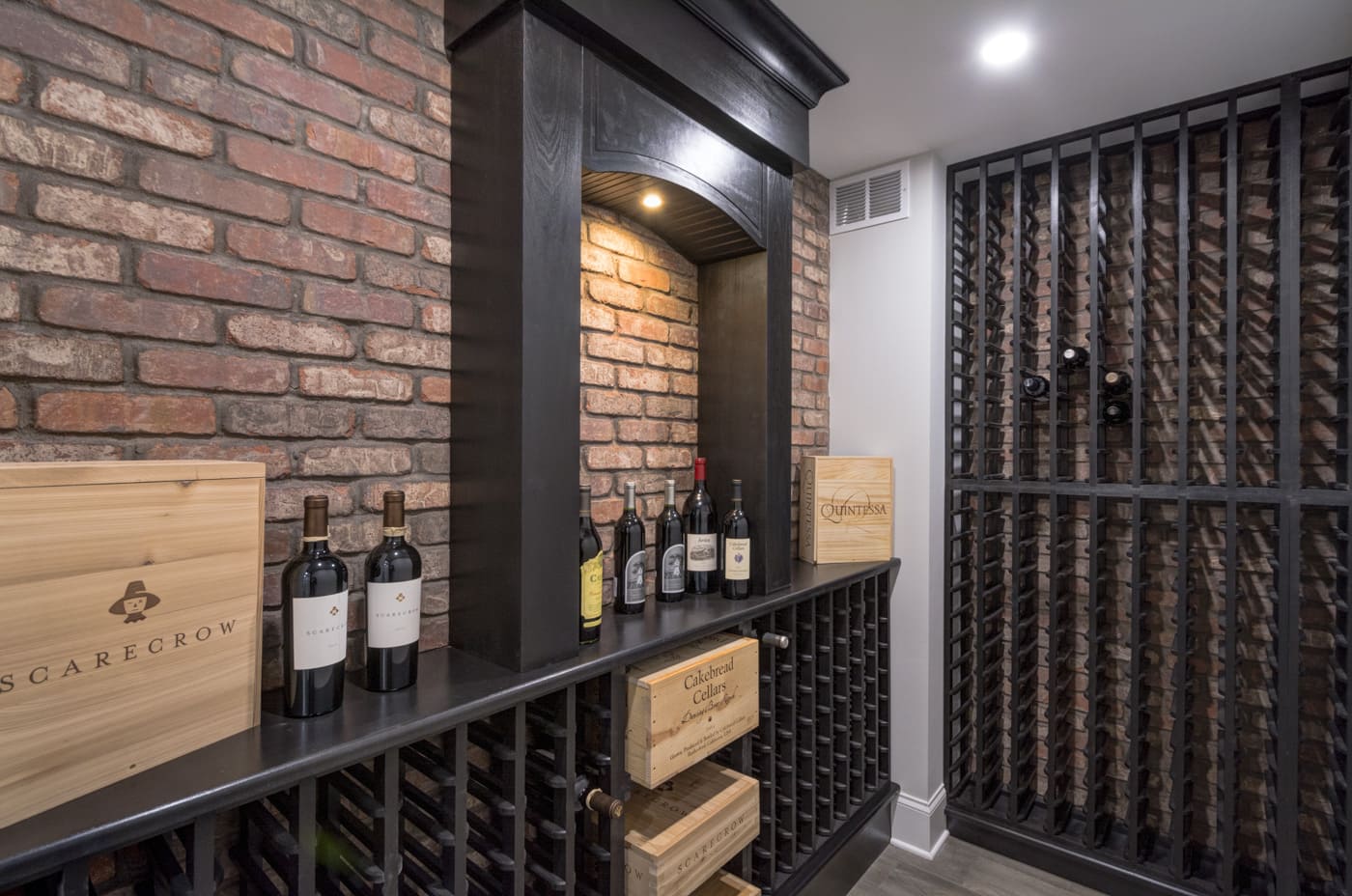 Elegant wine storage room with exposed brick and wood wine racks in Silver Oak Remodelings Atlanta home build