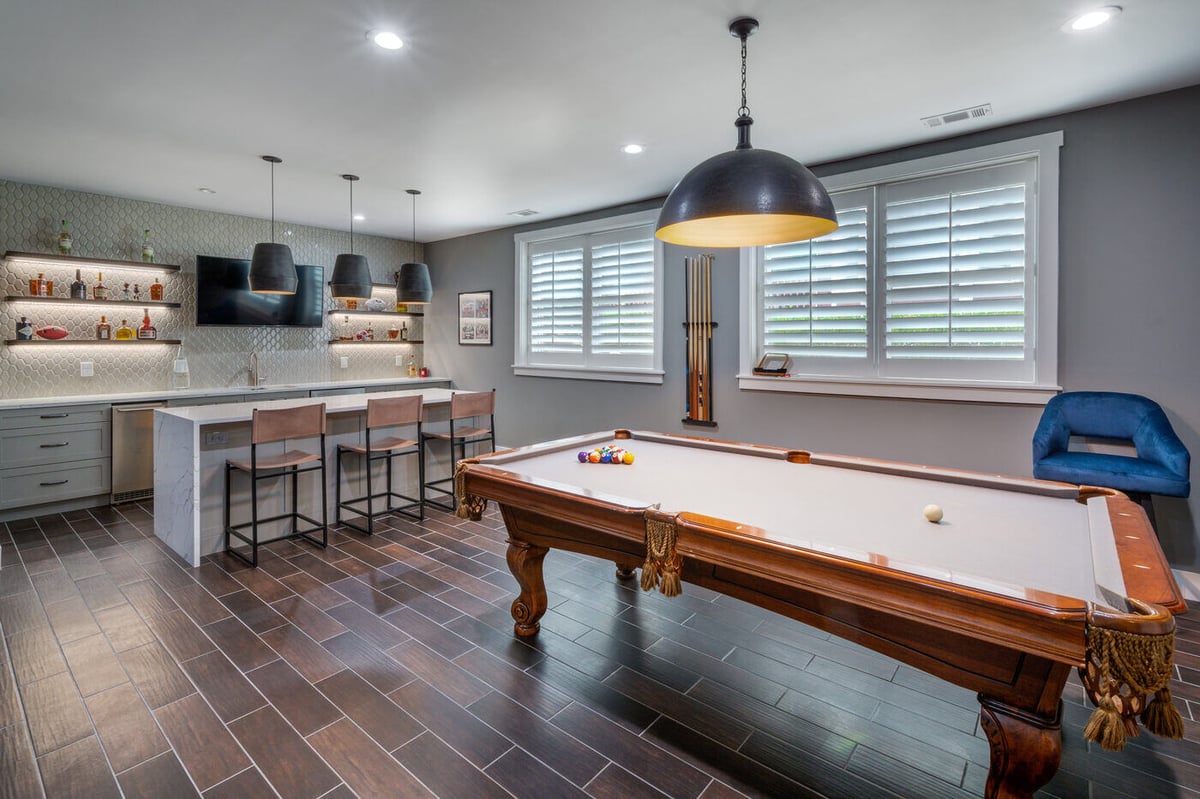 Game area in Atlanta basement remodel by Silver Oak Remodel with pool table and built-in bar