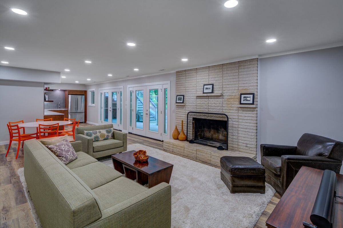 Open concept basement living area with fireplace and dining nook in Atlanta GA by Silver Oak Remodel