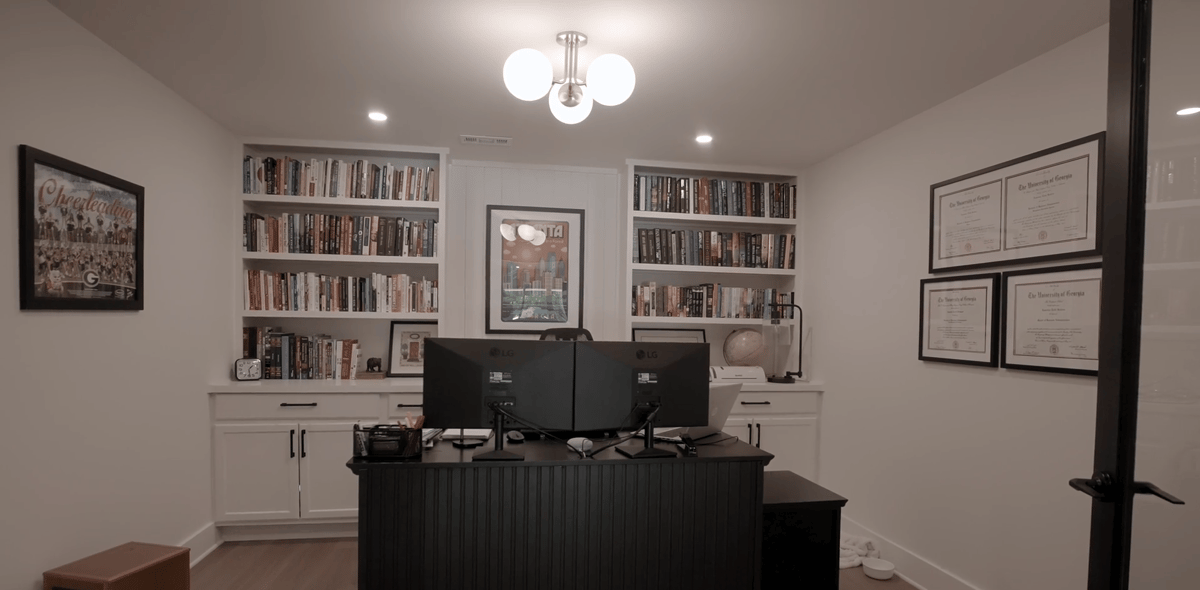 Remodeled Silver Oak basement office featuring custom bookshelves, cabinets, and workspace in Atlanta, GA.