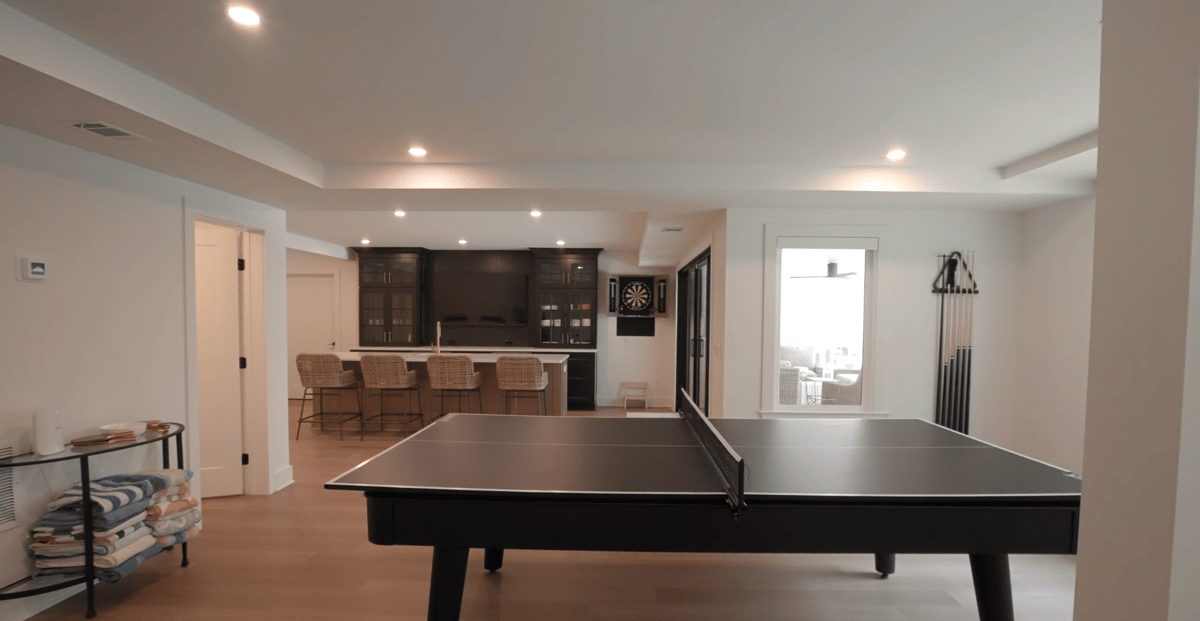 Silver Oak Remodel basement recreation room with ping pong table and custom bar in Atlanta, GA.
