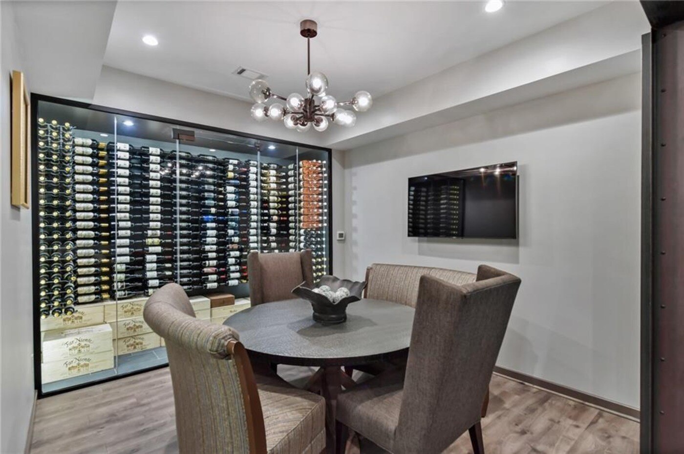 Wine tasting room with glass cellar and round table by Silver Oak Remodel in Atlanta, GA