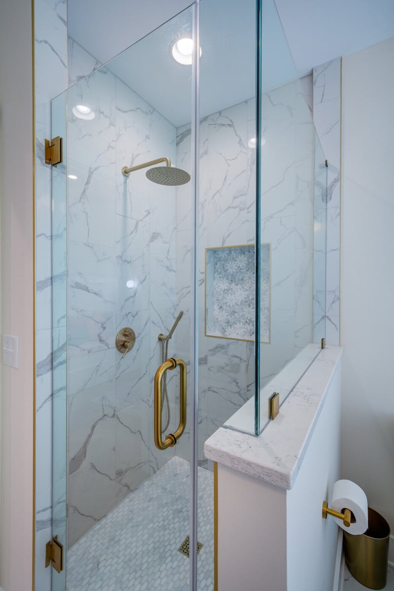 Full view of marble and glass shower with gold accents in an Atlanta, GA bathroom remodel by Silver Oak Remodel