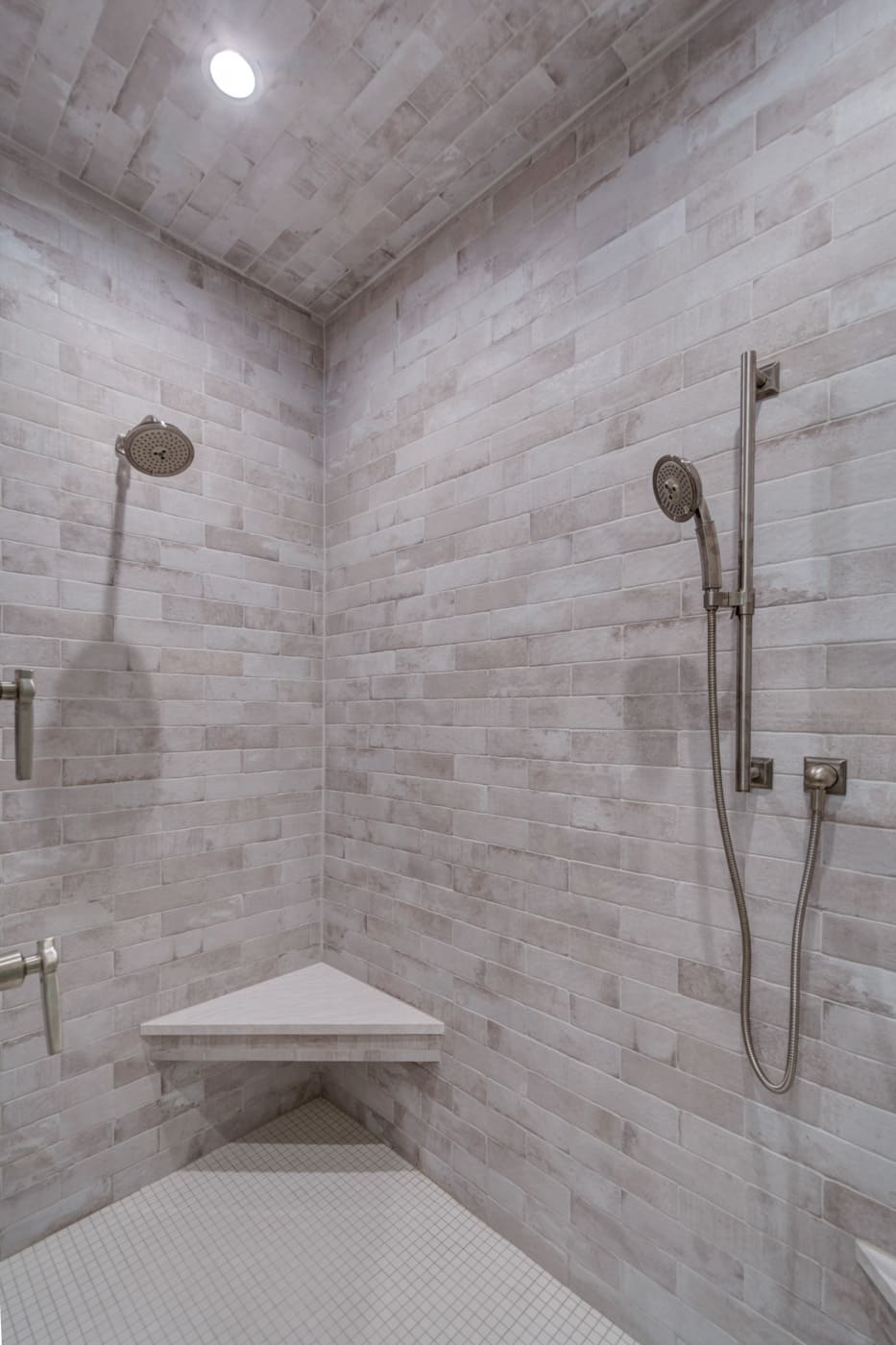 Fully tiled walk-in shower with rainfall head and corner bench in a Silver Oak Remodeling project in Atlanta, GA