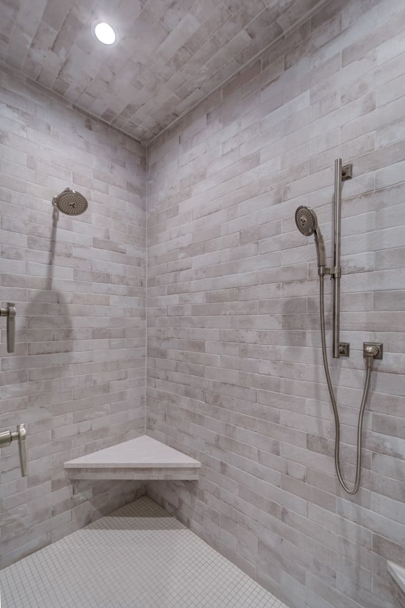 Fully tiled walk-in shower with rainfall head and corner bench in a Silver Oak Remodeling project in Atlanta, GA