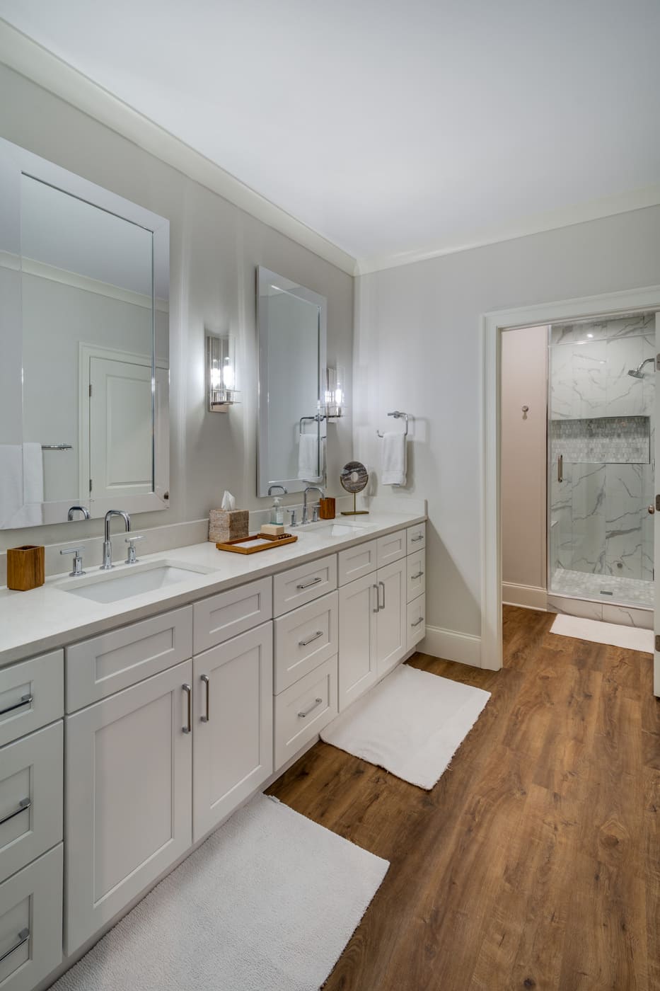 Large bathroom with white cabinets, wood floors, and walk-in shower by Silver Oak Remodeling in Atlanta, GA