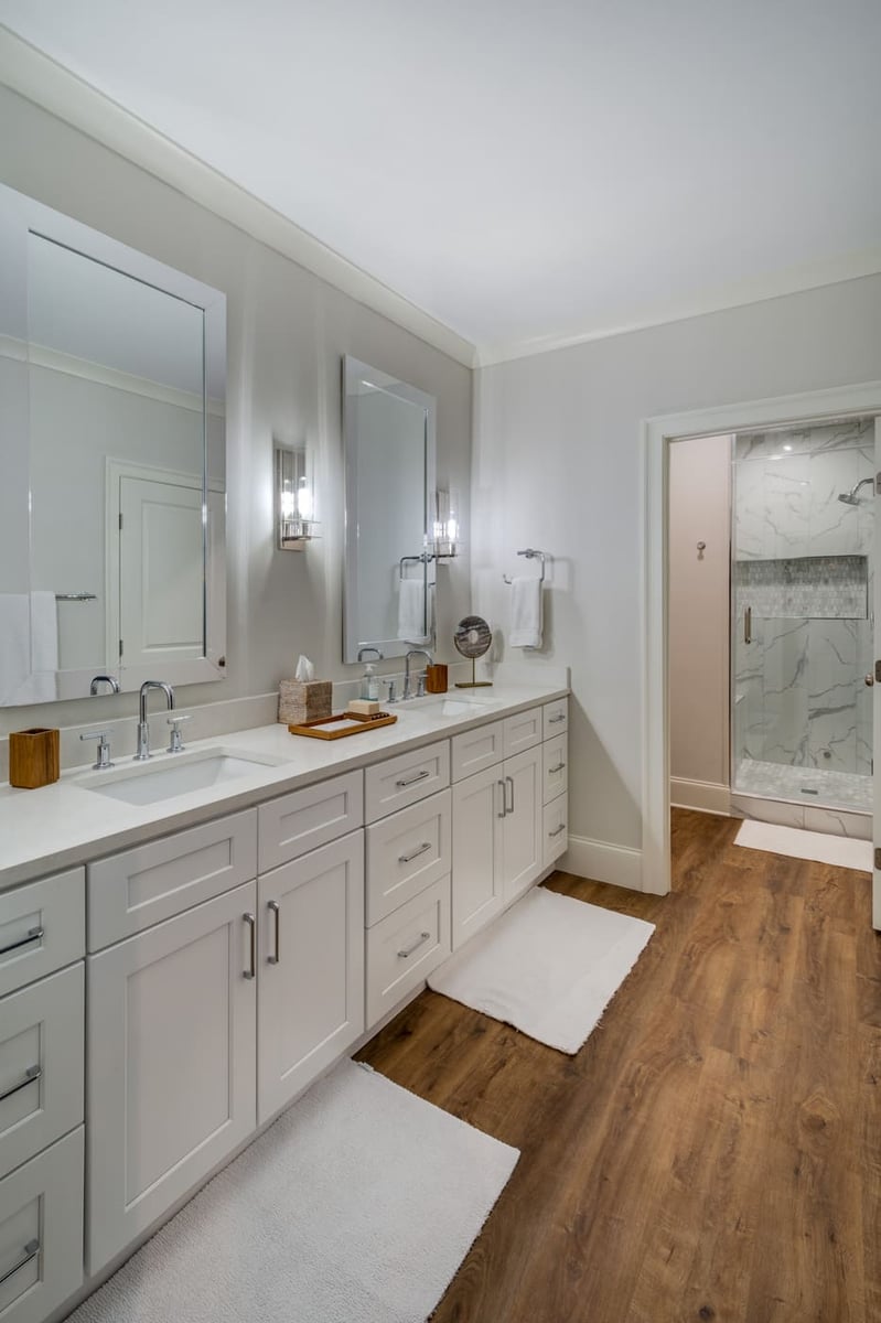 Large bathroom with white cabinets, wood floors, and walk-in shower by Silver Oak Remodeling in Atlanta, GA