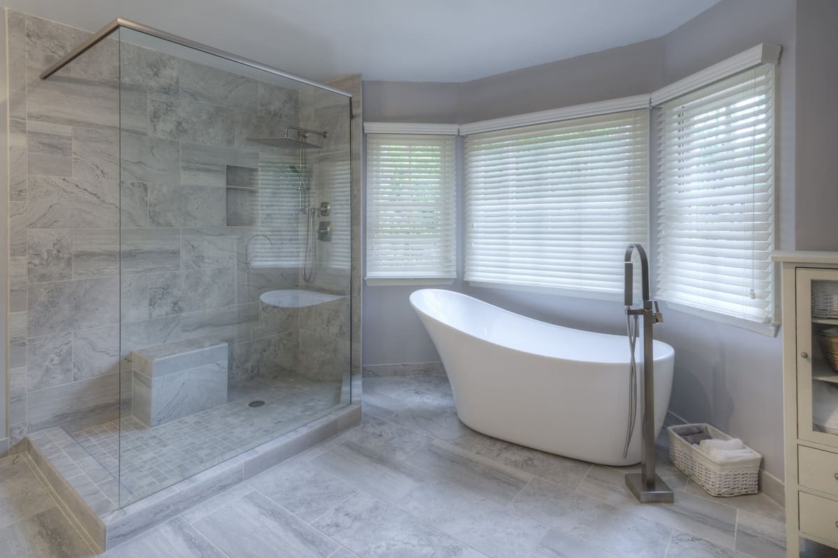 Serene bathroom with large corner tub and gray tile shower by Silver Oak Remodeling in Atlanta, GA