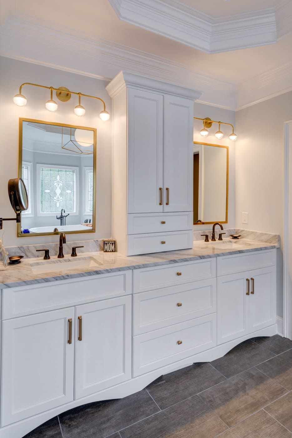 Elegant master bathroom vanity with brass fixtures and custom mirrors in an Atlanta home by Silver Oak Remodel