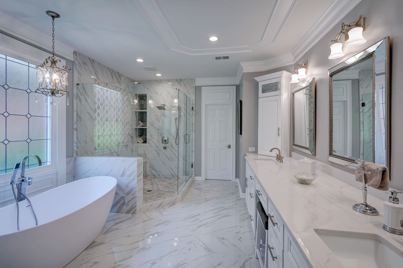 Upscale bathroom design featuring crystal lighting and white vanity from an Atlanta Silver Oak Remodeling proj