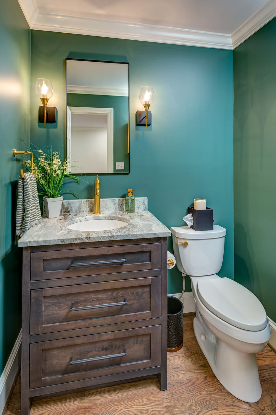 Small bathroom with dark vanity, green walls, and gold fixtures in an Atlanta custom home by Silver Oak Remodeling