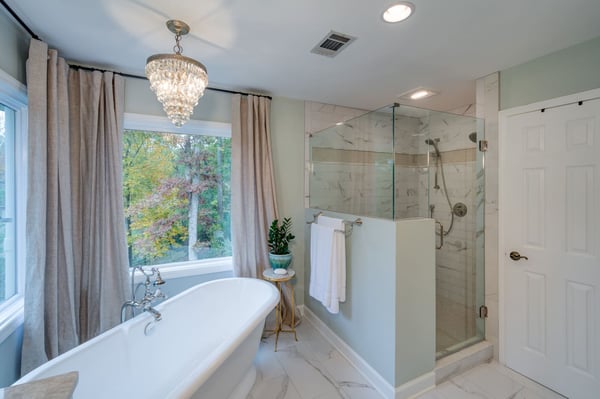 Transitional bathroom with freestanding tub, marble tile, and natural light in an Atlanta custom home by Silver Oak
