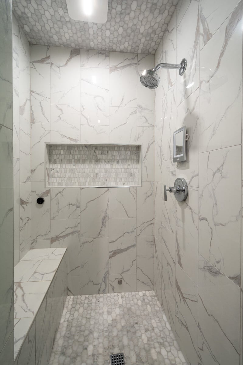 Walk-in marble tile shower with niche and bench by Silver Oak Remodel in Atlanta, GA