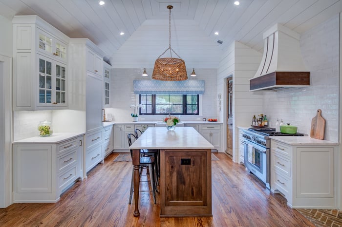 Bright farmhouse kitchen with large island and white cabinetry by Silver Oak in Roswell, GA