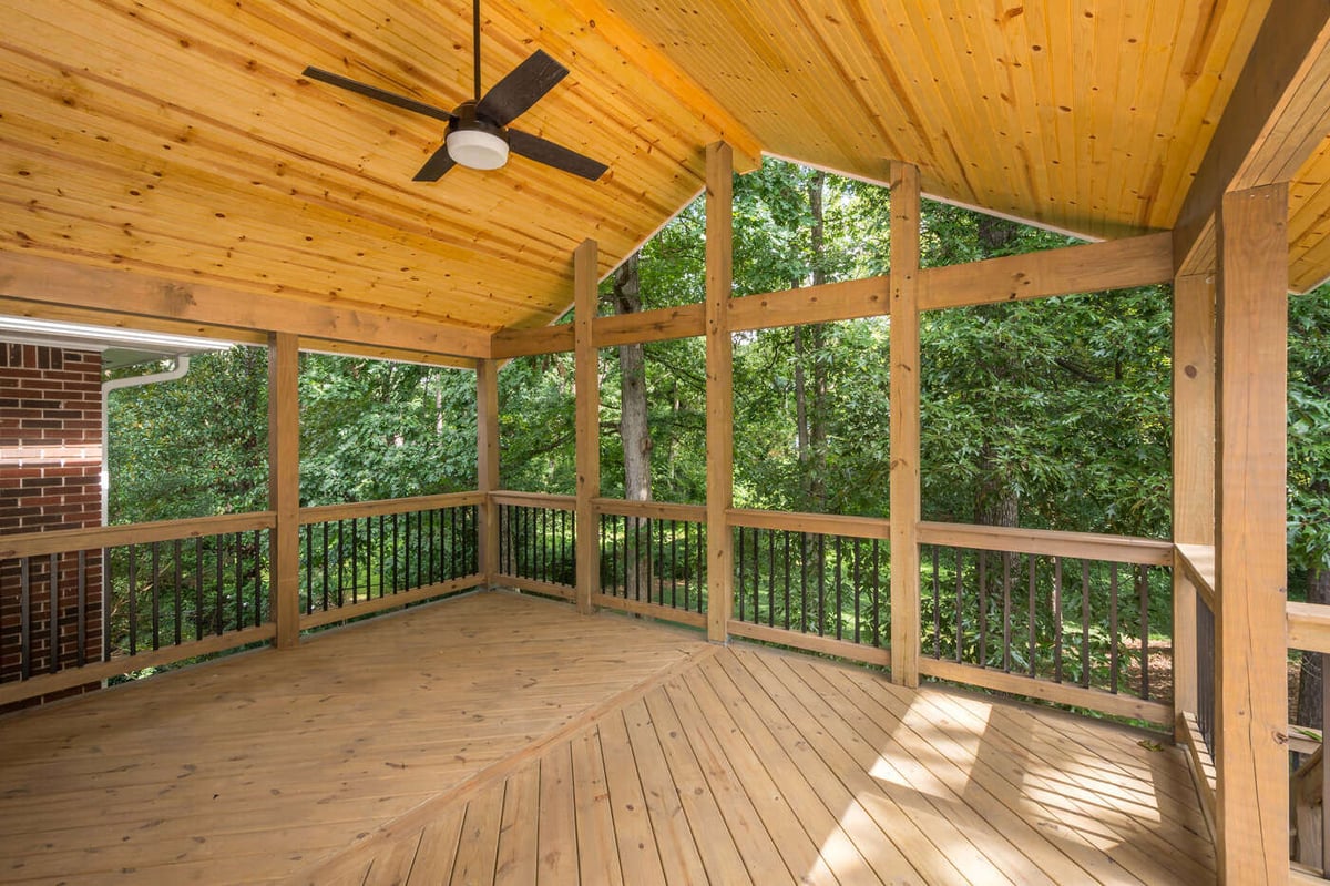 Newly built wooden porch with vaulted ceiling overlooking wooded backyard in Atlanta, GA by Silver Oak Remodel