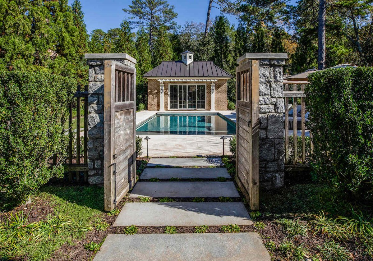 Poolside pavilion with gated stone entryway in Atlanta, GA outdoor remodel by Silver Oak Remodel