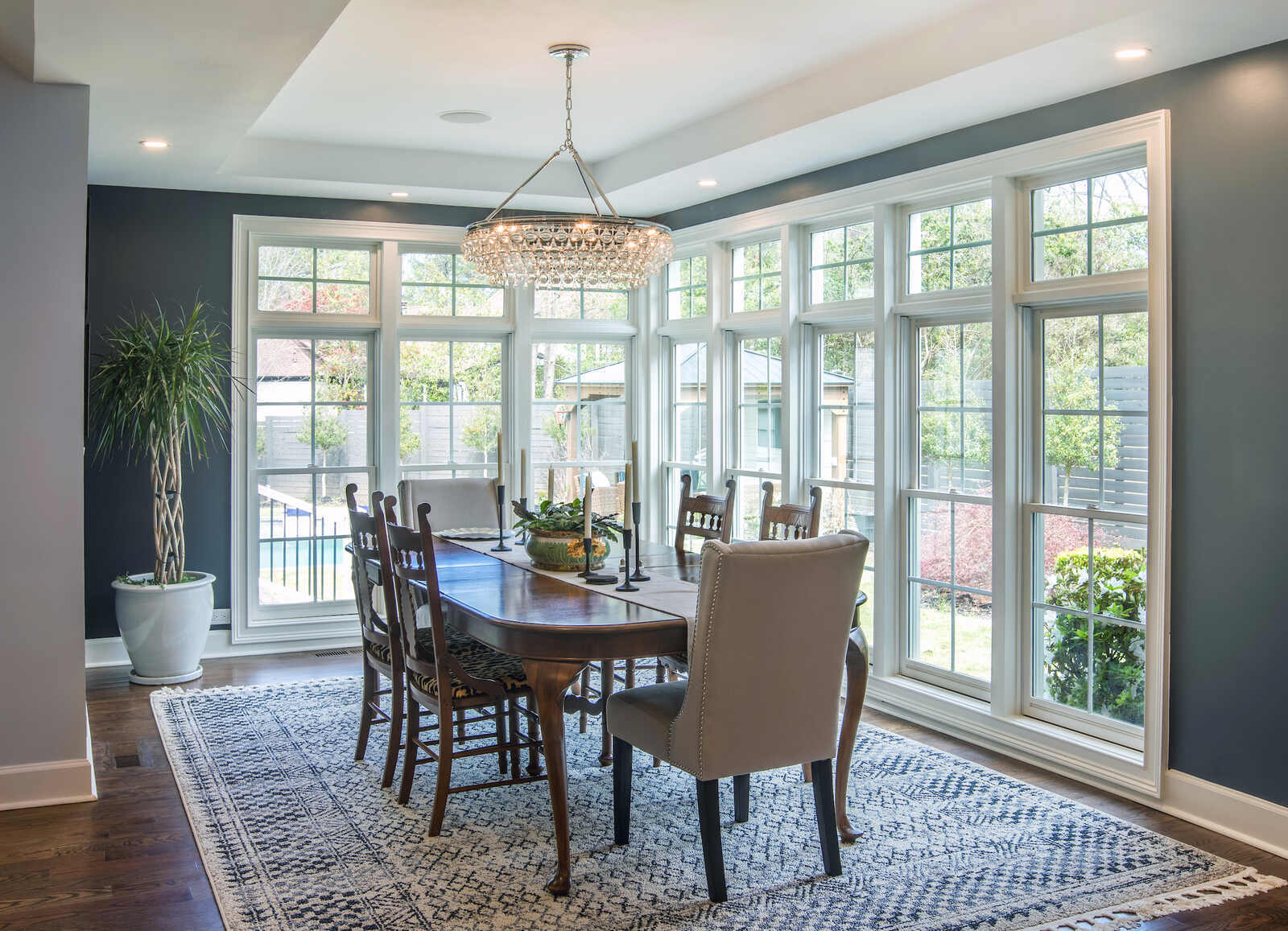 Dining area remodel by Silver Oak Remodel in East Cobb, GA with wall of windows and crystal chandelier