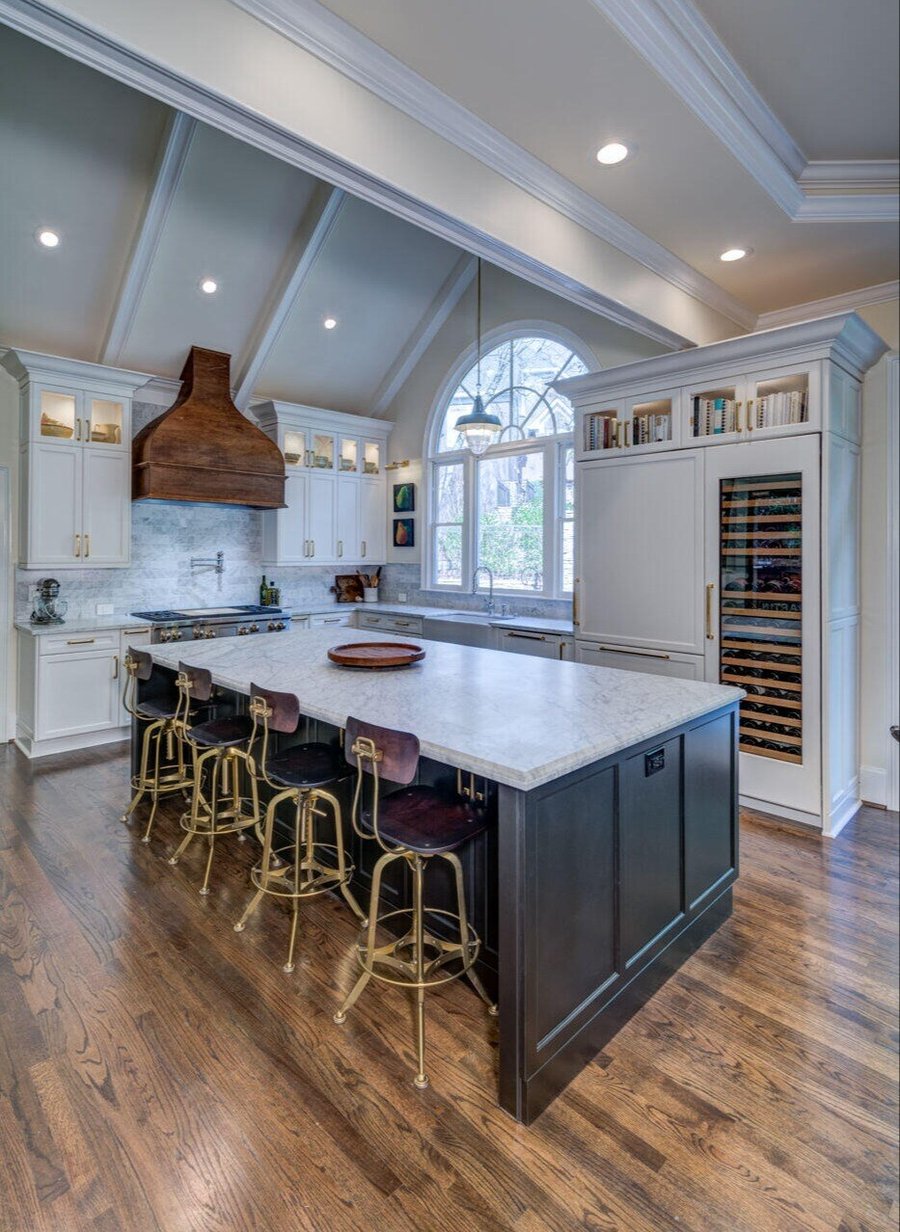 Vaulted ceiling kitchen with dark island and custom range hood