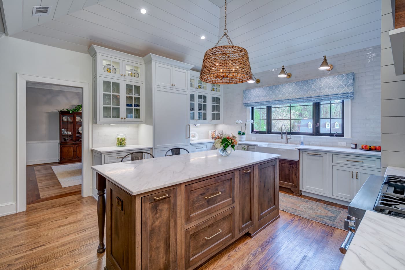 Classic white kitchen with wood island and pendant light in Atlanta custom home by Silver Oak Remodeling