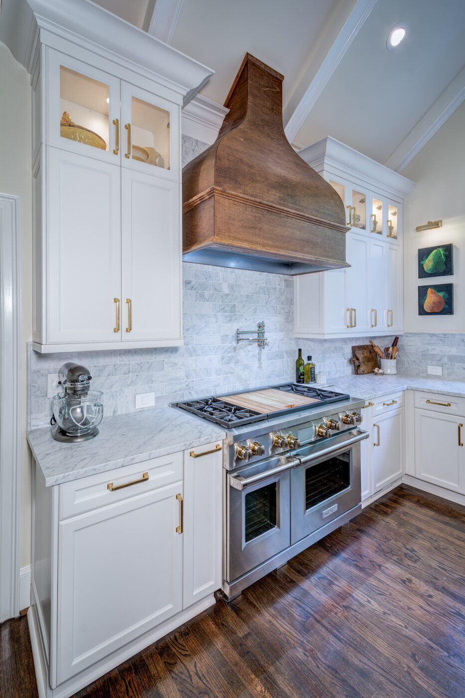 Detail of kitchen cooktop area in Atlanta, GA remodel by Silver Oak Remodel with white marble and brass finishes