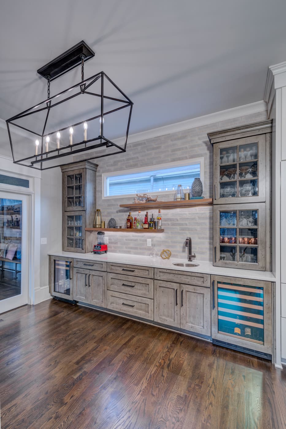 Home bar area with rustic wood cabinetry and under-counter wine fridge by Silver Oak Remodeling in Atlanta, GA