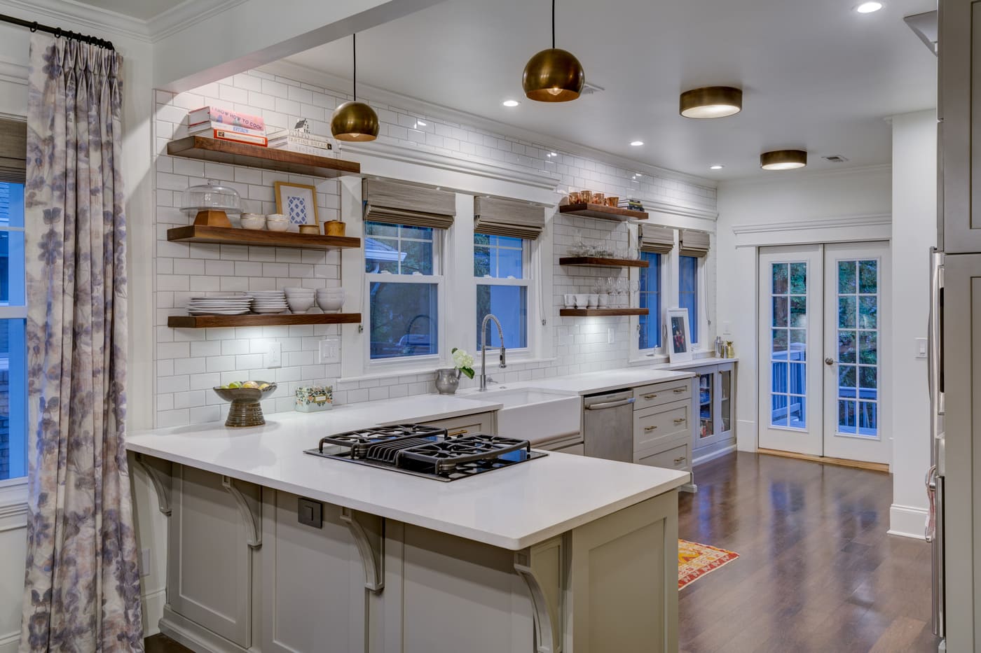 Open-concept kitchen with white cabinets, wood shelves, and island in Atlanta custom build by Silver Oak Remodeling