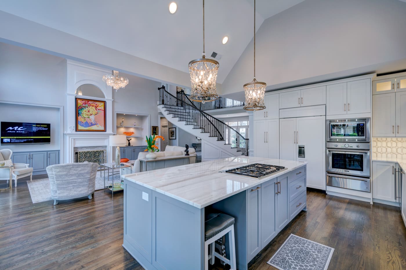 Open-concept living area and kitchen with island and chandeliers in Atlanta home by Silver Oak Remodeling