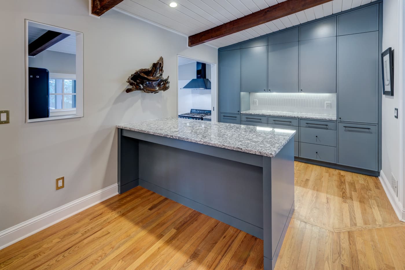 Transitional kitchen design with blue cabinetry and wood floors in Atlanta home by Silver Oak Remodeling