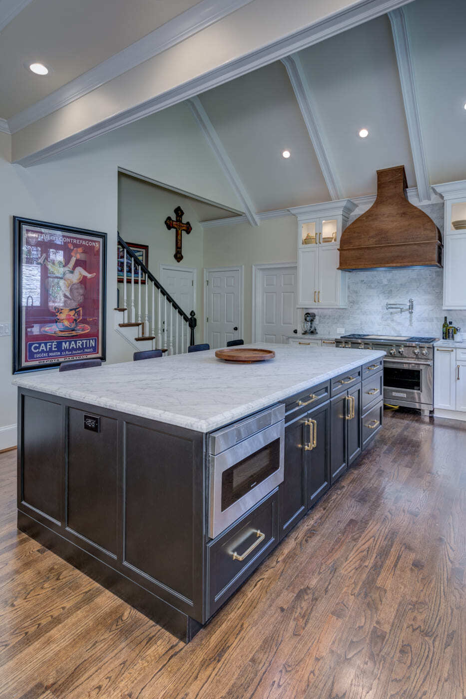 Vaulted ceiling kitchen with marble island and statement range hood by Silver Oak Remodeling in Atlanta, GA