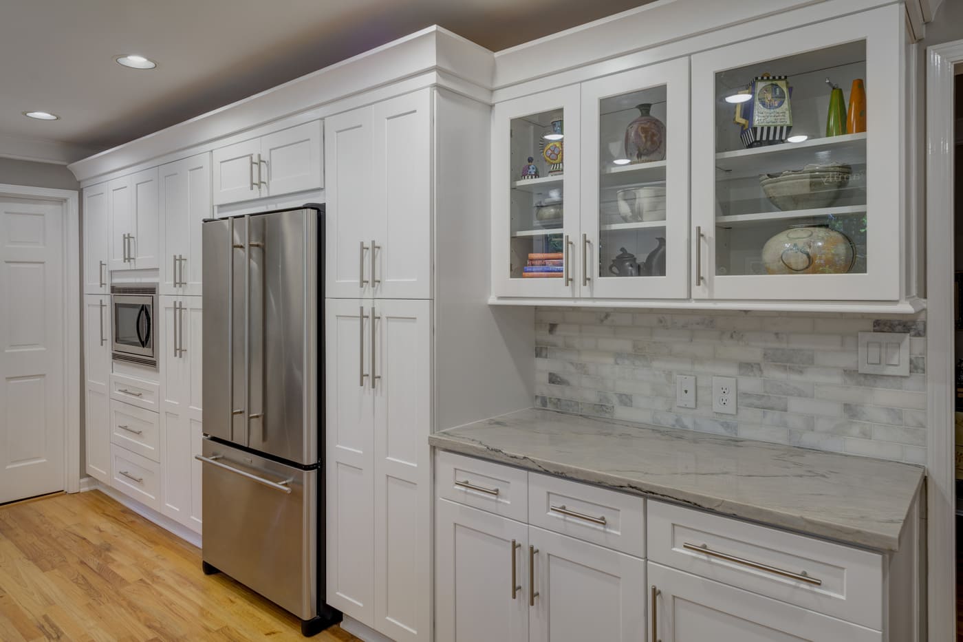 White kitchen remodel with stainless appliances and marble backsplash by Silver Oak Remodeling in Atlanta, GA