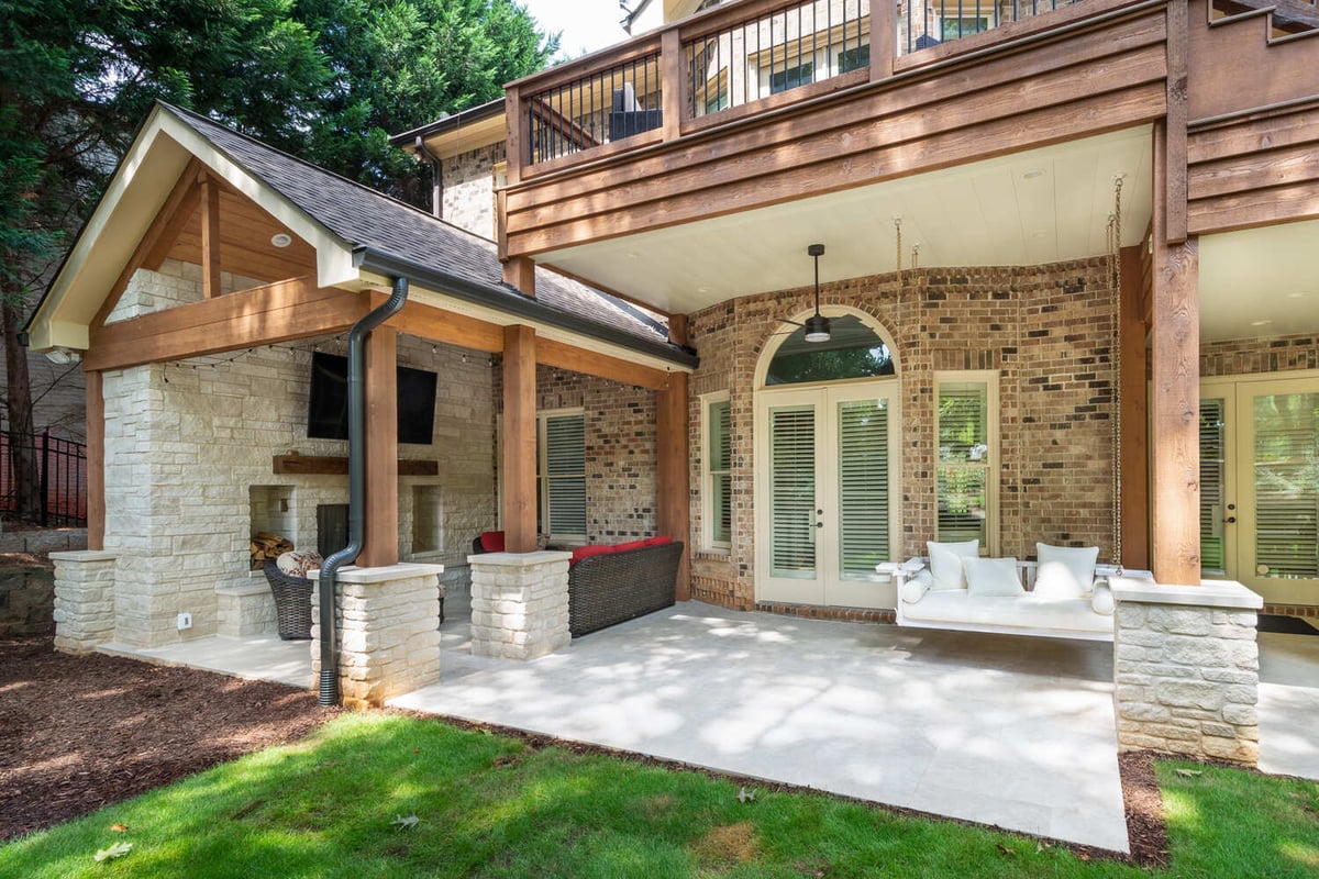 Outdoor fireplace with mounted TV and cozy seating by Silver Oak Remodel in Atlanta, GA
