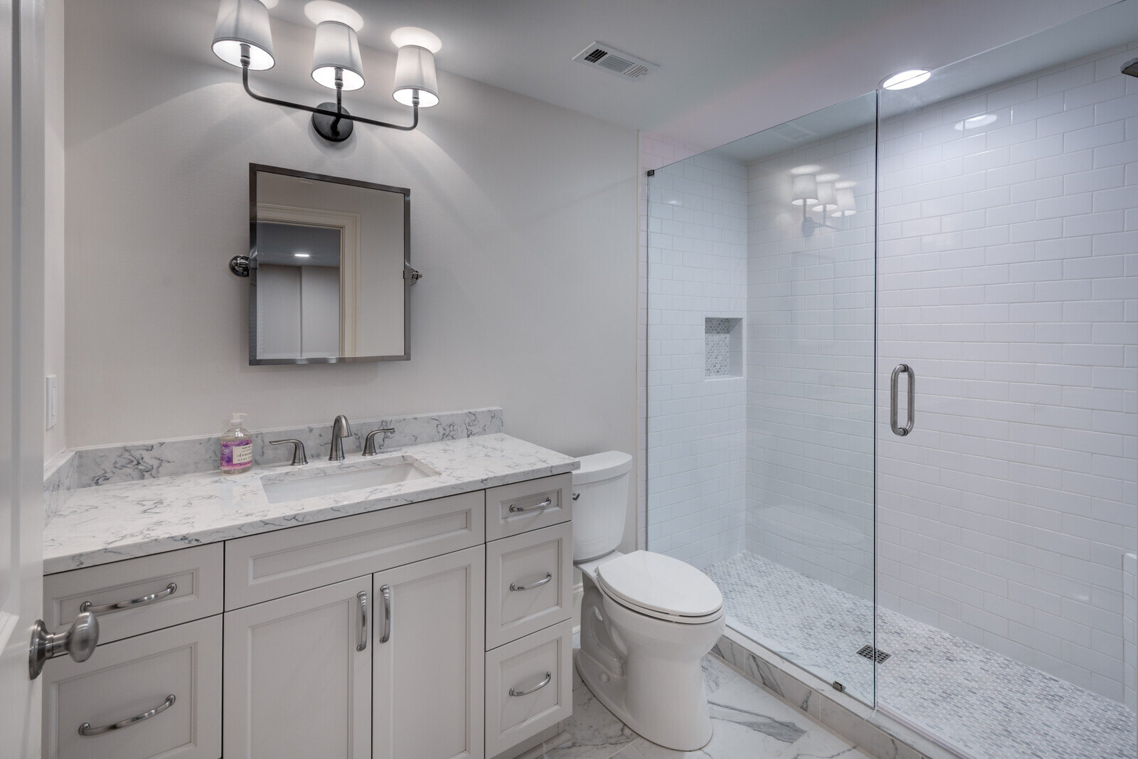 Elegant basement bathroom remodel with marble vanity and walk-in shower by Silver Oak Remodel in Roswell GA