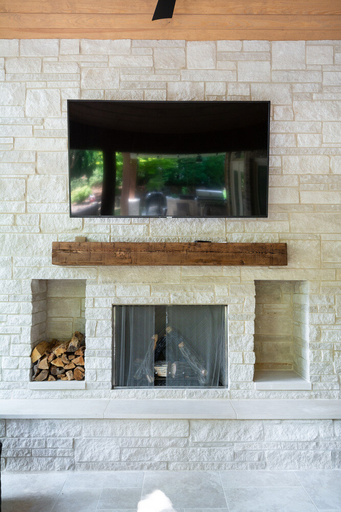 Close-up of a stone fireplace with mounted TV in an outdoor living area remodeled by Silver Oak Remodel in Atlanta, GA