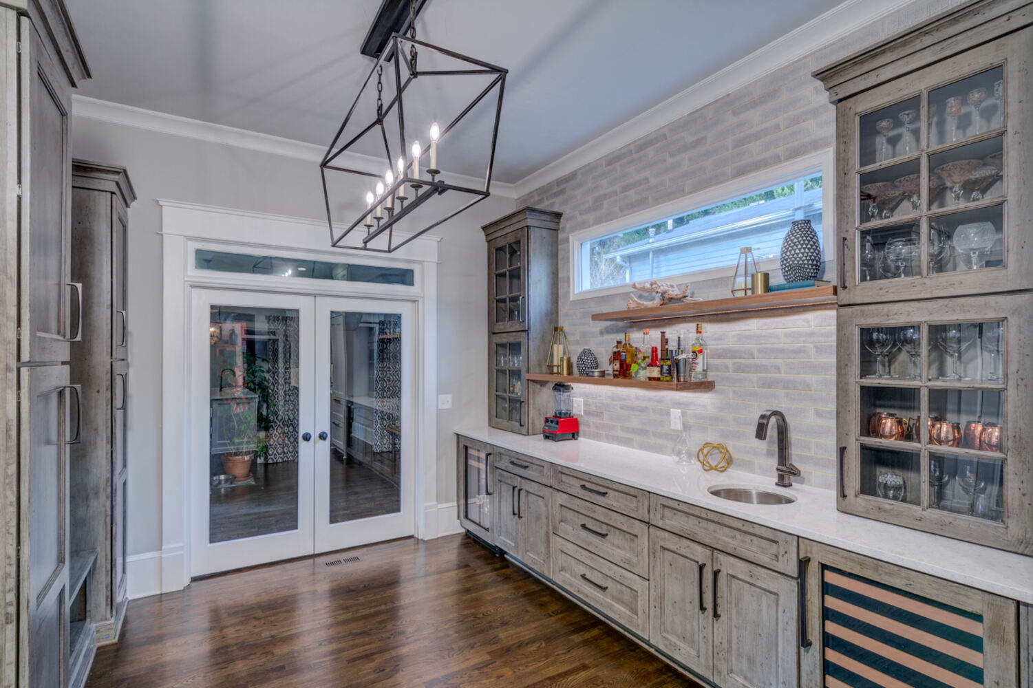 Full view of modern rustic home bar with French doors and pendant lighting by Silver Oak Remodel in Atlanta, GA
