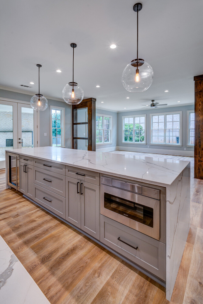 Large quartz island and pendant lights in modern Brookfield kitchen remodel by Silver Oak Remodel