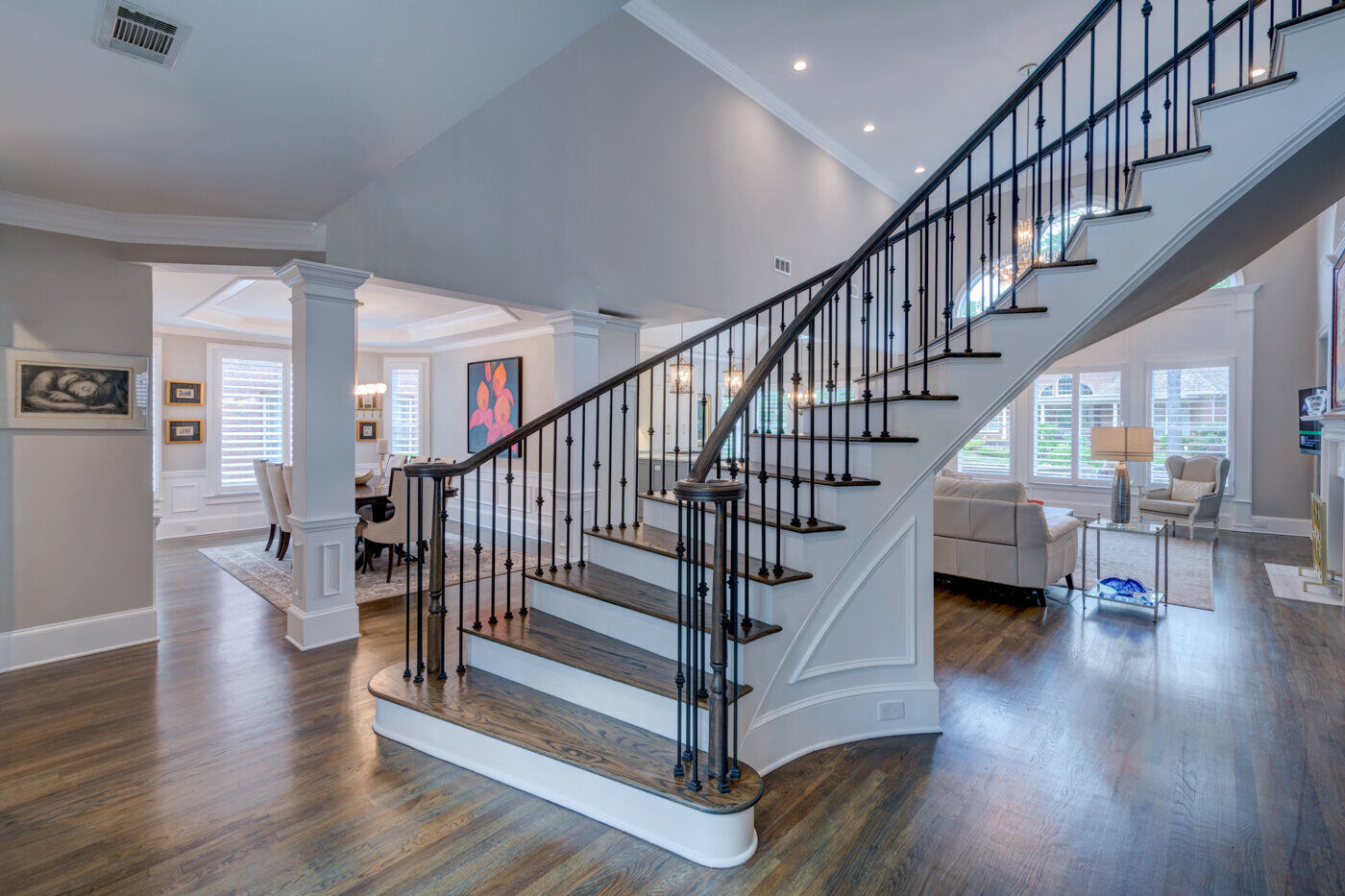 Curved staircase and dining room view in home remodel by Silver Oak Remodel in Sandy Springs, GA