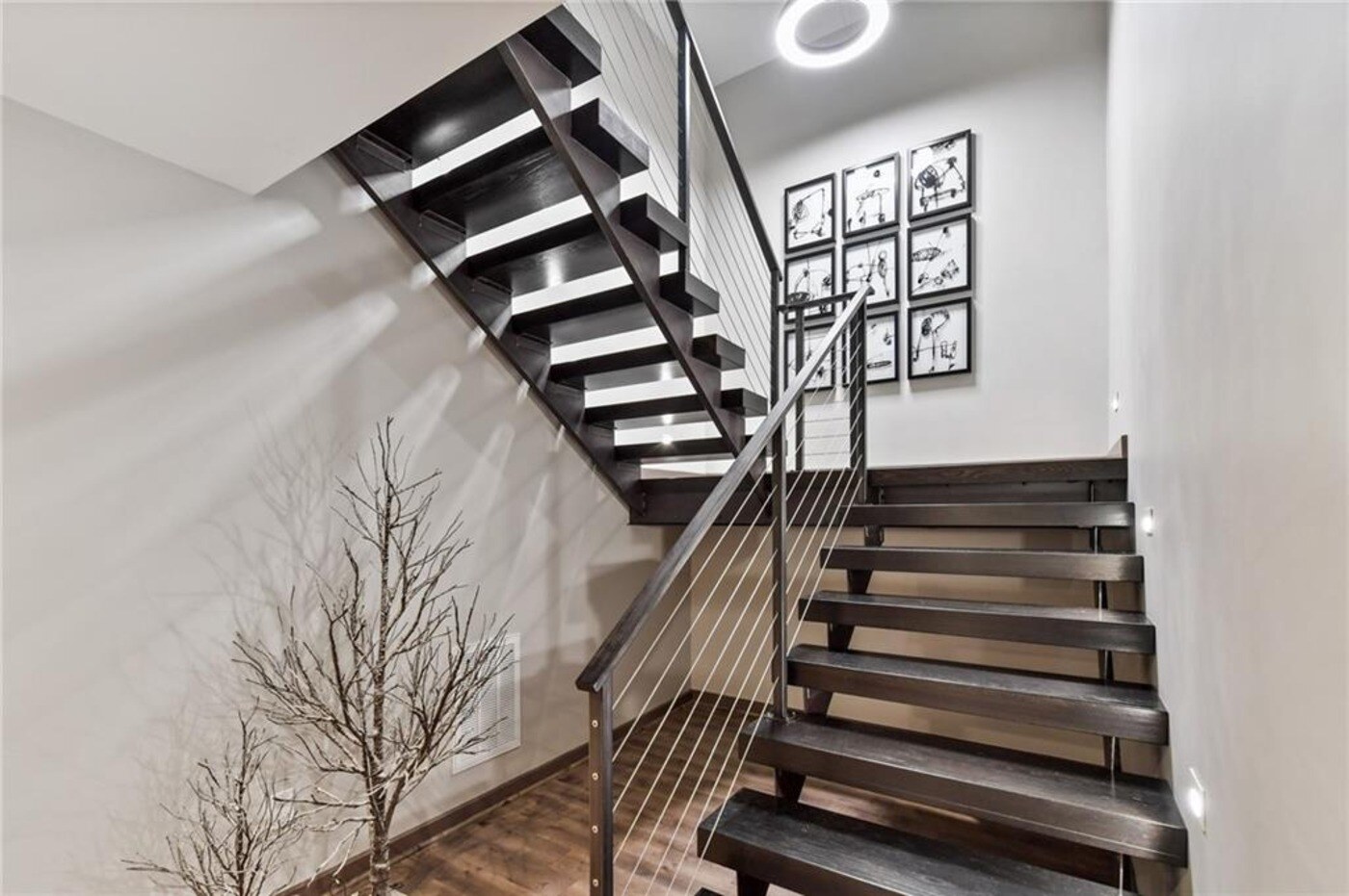 Floating staircase with cable railing in modern basement remodel by Silver Oak Remodel in Atlanta, GA