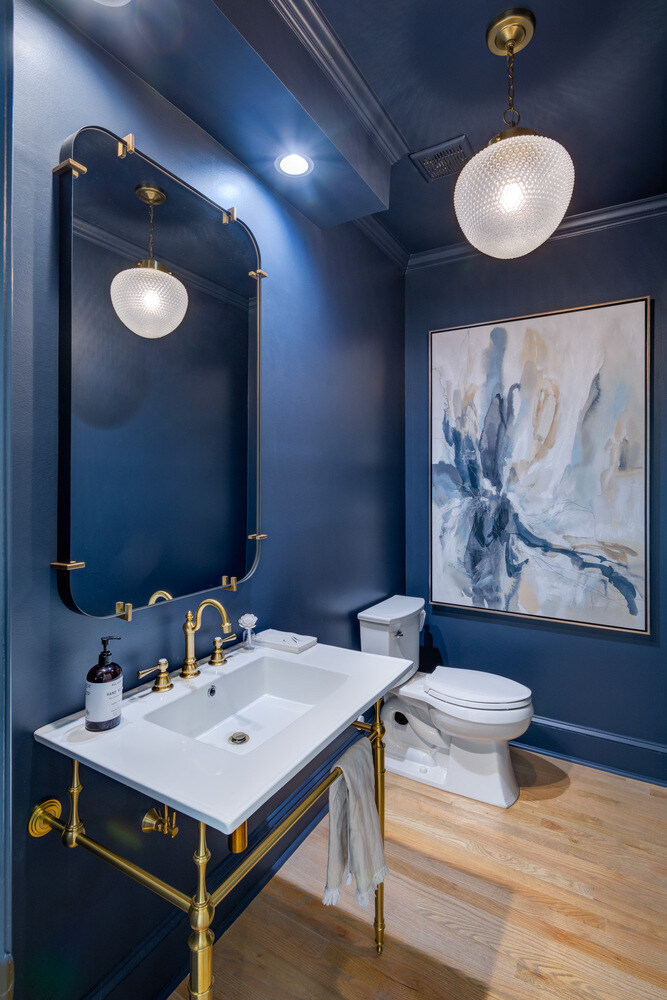 Elegant powder room with navy walls and brass fixtures in Brookfield remodel by Silver Oak Remodel