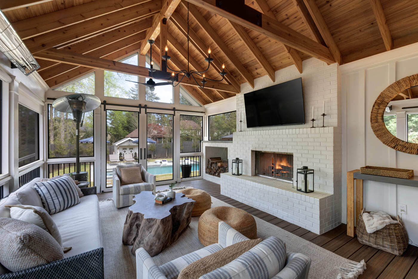 Cozy screened patio with wood ceiling and white brick fireplace in Atlanta by Silver Oak Remodeling